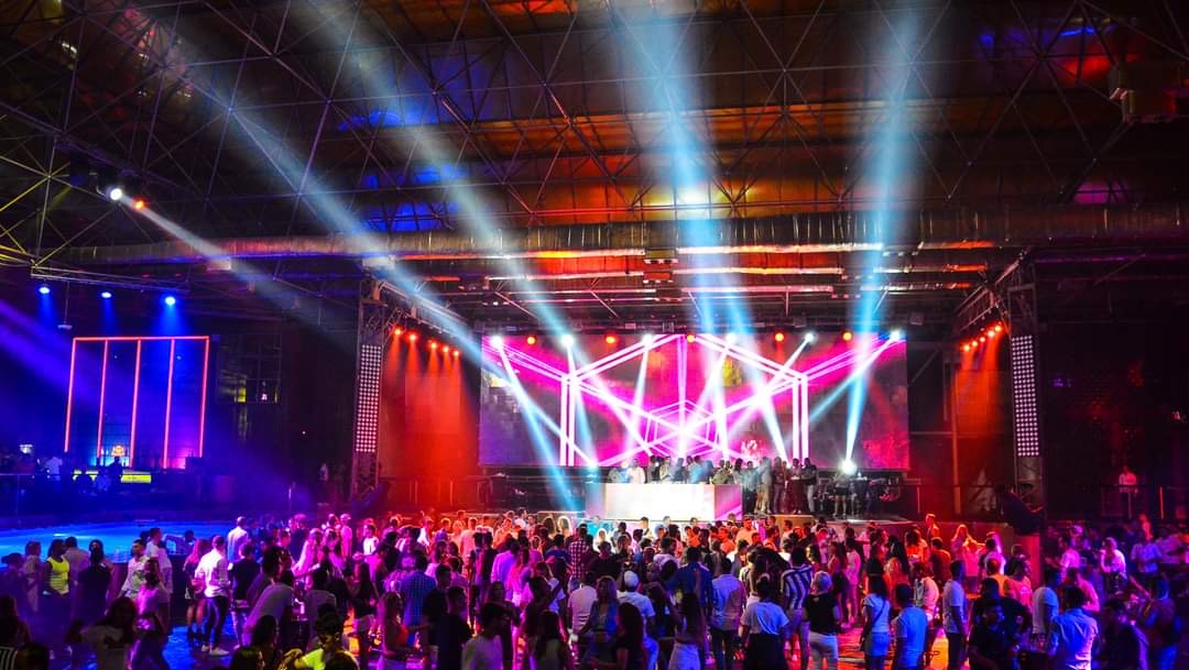 Taj Mahal stage and crowd under red and white light beams